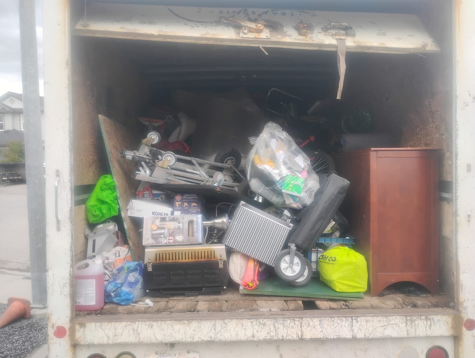 A storage unit packed with furniture and stored belongings being cleared out by Clearout Crew in the Calgary area.